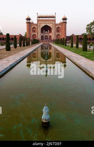 Uno scatto verticale della porta reale con il riflesso in una pozza d'acqua di fronte ad esso, Taj Mahal, Agra Foto Stock