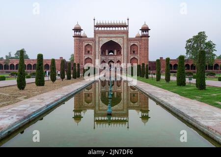 Un colpo della porta reale con il riflesso in una piscina d'acqua di fronte ad esso, Taj Mahal, Agra Foto Stock