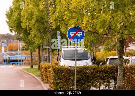 Una messa a fuoco selettiva di un cartello che mostra la fine della corsia degli autobus vicino a un parco Foto Stock