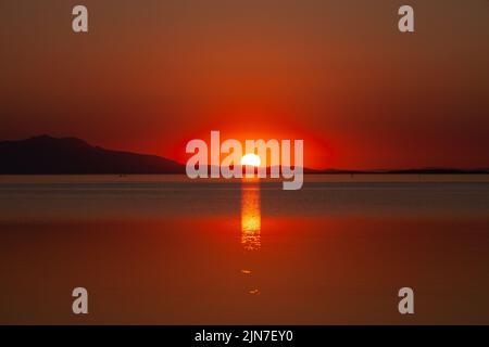 Tramonto sul mare sulla spiaggia. sole all'orizzonte. Tramonto sulla costa della Turchia, Ayvalik Foto Stock