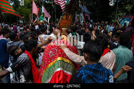 I musulmani sciiti del Bangladesh marciano e portano le bandiere e Tazia durante una processione di Muharram sulla strada principale a Dhaka, Bangladesh, il 09th agosto 2022. Foto Stock