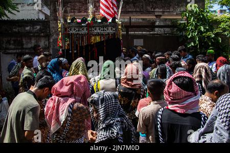 I musulmani sciiti del Bangladesh marciano e portano le bandiere e Tazia durante una processione di Muharram sulla strada principale a Dhaka, Bangladesh, il 09th agosto 2022. Foto Stock