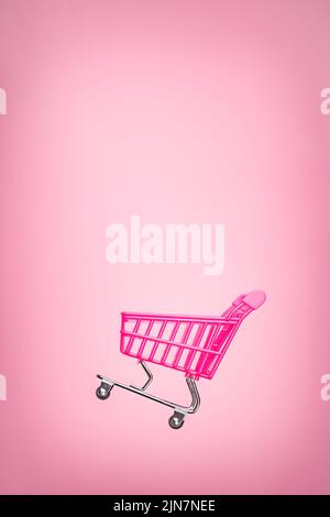 Carrello carrello vuoto isolato sfondo rosa. Carrello per lo shopping rosa concetto supermercato. TOY rosa concept vendite online carrello vendita supermercato Foto Stock