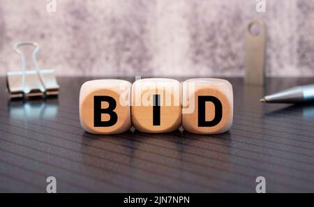 Tre cubi di legno con lettere OFFERTA, su tavola bianca e diagramma, business concept Foto Stock