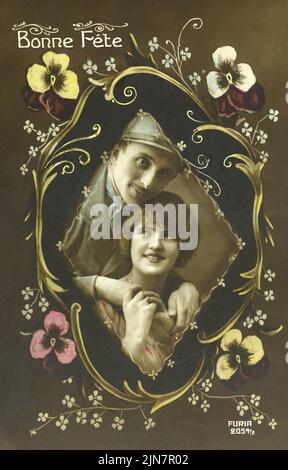 ' Bonne Fete ' Fotografia vintage a mano di giovane coppia con bordo decorativo dipinto floreale circa 1920 Foto Stock