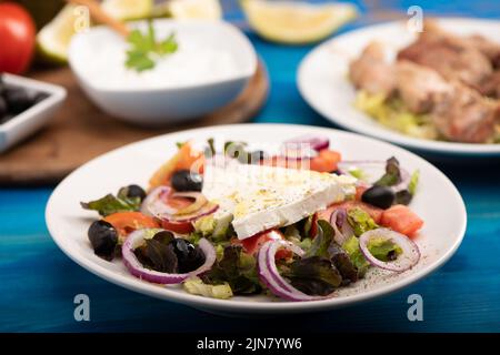 Un'insalata greca rustica servita su un piatto bianco da vicino Foto Stock