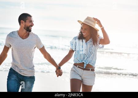 Una giovane coppia che cammina lungo la spiaggia. Foto Stock