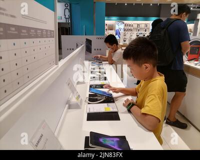 Shenzhen, Cina: A causa dell'impatto dell'epidemia, il negozio di elettrodomestici Shundian ha pochi clienti. Alcuni bambini stanno giocando con il mobile campione Foto Stock