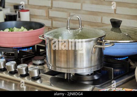 Pentole con cibo da cucina in cucina su stufa a gas Foto Stock