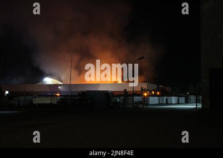 2022-08-10 00:29:34 Almelo - martedì 9 agosto, un incendio si è verificato al Twente Business Park di Almelo intorno alle 11:10 PM. Un edificio commerciale era in fiamme. Il fuoco è stato presto scalato fino al segnale del "grande fuoco molto". Era un fuoco ardente. Erano presenti diversi motori antincendio. Per un po', il fuoco causò grandi pennacchi di fumo. Questi pennacchi di fumo potevano essere visti da chilometri circa. Non è noto come sia iniziato il fuoco. L'incendio ha causato molti danni. Per quanto è noto, nessuno è stato ferito nel fuoco. La strada è stata chiusa durante il servizio antincendio. Questo ha causato un'interruzione del traffico per gli utenti della strada Foto Stock