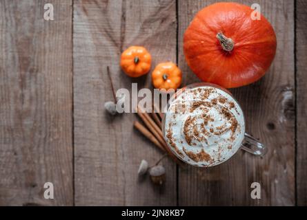 Bevanda di zucca piccante autunnale, latte di zucca su sfondo di legno vista dall'alto Foto Stock