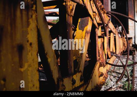 Telaio del ponte in ferro e bullone e bicicletta. Carro abbandonato giallo e arrugginito. Telaio in metallo giallo arrugginito. Abbandonata macchina di metallo giallo con rivetti. Foto Stock