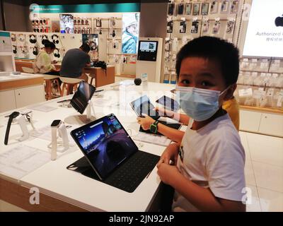 Shenzhen, Cina: A causa dell'impatto dell'epidemia, il negozio di elettrodomestici Shundian ha pochi clienti. Alcuni bambini stanno giocando con il mobile campione Foto Stock