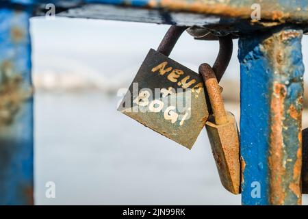 Un mucchio di lucchetti arrugginiti sul recinto blu del ponte. Foto Stock