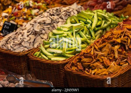 Avocado, cocco e altre frutta a fette in un cestino di vimini al mercato Boqueria di Barcellona (Spagna), Foto Stock