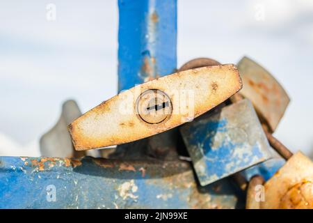 Un mucchio di lucchetti arrugginiti sul recinto blu del ponte. Foto Stock