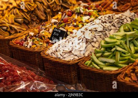 Avocado, cocco e altre frutta a fette in un cestino di vimini al mercato Boqueria di Barcellona (Spagna). Foto Stock