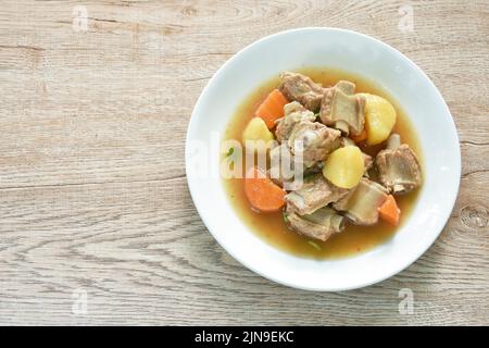 osso di maiale bollito con stufato di patate e carote sul piatto Foto Stock