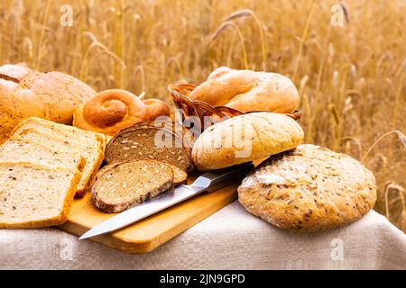 lotto di pane, grano, segale aromatizzato, sulla tavola all'esterno del campo Foto Stock