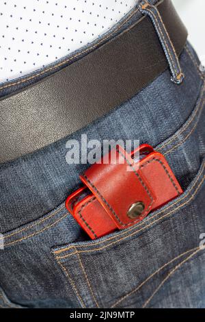 Custodia porta carte di credito artigianale di lusso in pelle. Scatola in pelle rossa per carte di credito nella tasca posteriore dei jeans. Foto Stock