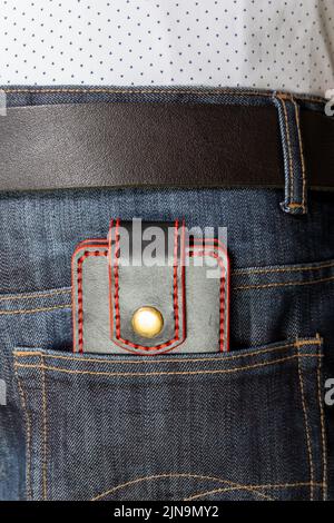 Custodia porta carte di credito artigianale di lusso in pelle. Scatola in pelle nera per carte di credito nella tasca posteriore dei jeans. Foto Stock