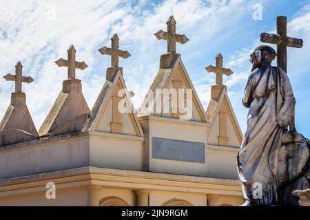 Modello di croci lapidi in cimitero in una fila e cielo chiaro Foto Stock