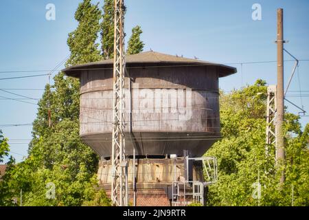Una vecchia torre arrugginita con alberi sullo sfondo in una giornata senza nuvole Foto Stock