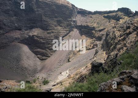 Primi piani intorno al cono in cima al Vesuvio Italia che mostra i diversi strati di roccia rivolti verso la bocca chiusa. Foto Stock