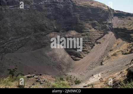 Primi piani intorno al cono in cima al Vesuvio Italia che mostra i diversi strati di roccia rivolti verso la bocca chiusa. Foto Stock