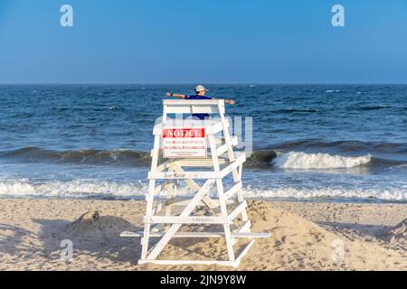 Giovane ragazzo seduto in un stand di guardia alla spiaggia di Mecox Foto Stock