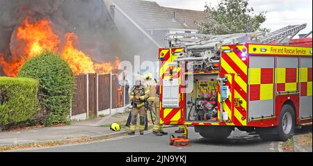 Vigili del fuoco gara Essex Fire and Rescue Service pompieri vigili del fuoco a fuoco casa fiamme ablaze fumo nero vicino Inghilterra UK Foto Stock