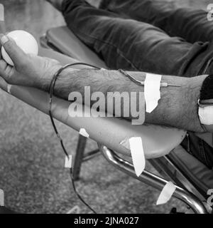 Donatore di sangue al campo di donazione di sangue tenuto con una palla rimbalzante in mano al Tempio Balaji, Vivek Vihar, Delhi, India, Image for World Blood Donor da Foto Stock