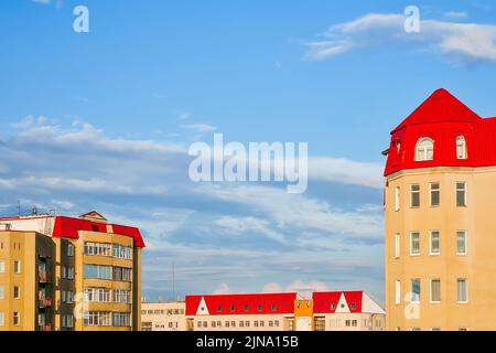 Alto edificio residenziale con tetto di tegole rosse contro il cielo blu. Vista aerea. Foto Stock