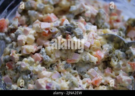 Tradizionale insalata russa Olivier di salsiccia bollita piselli verdi sottaceto, uova e maionese Foto Stock