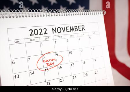 Concetto di giorno di elezione. Calendario da tavolo con il 8 2022 novembre contrassegnato in rosso e bandiera USA sullo sfondo Foto Stock