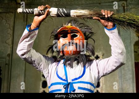 Un uomo indiano con una maschera che si esibisce durante il Dharohar Folk Dance Show a Udaipur, India Foto Stock