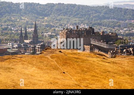 Grandi aree di erba sono diventato giallo a causa delle condizioni secche in Holyrood Park, Edimburgo. Lo Scottish Fire and Rescue Service (SFRS) ha issuto un rischio 'molto alto' di incendi selvatici allerta in tutta la Scozia meridionale e orientale con lunghi e secchi incantesimi di sole attesi nei prossimi giorni. Data foto: Mercoledì 10 agosto 2022. Foto Stock