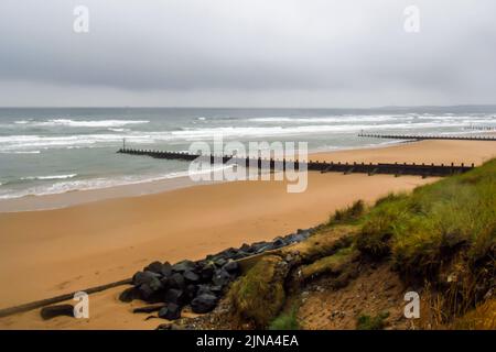 Vista sulla costa umida deserta di Aberdeen, nel nord della Scozia, con le nuvole temporesche che si radunano sullo sfondo. Foto Stock