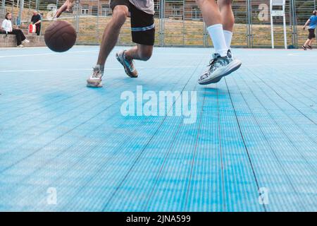 uomini che giocano a basket all'aperto raccolto Foto Stock