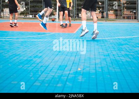 uomini che giocano a basket all'aperto raccolto Foto Stock