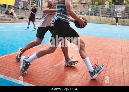uomini che giocano a basket all'aperto raccolto Foto Stock