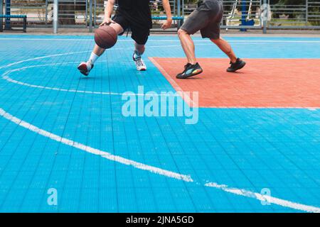 uomini che giocano a basket all'aperto raccolto Foto Stock