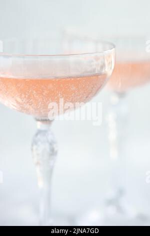 Primo piano di due bicchieri di champagne rosa in calici champagne coupé Foto Stock