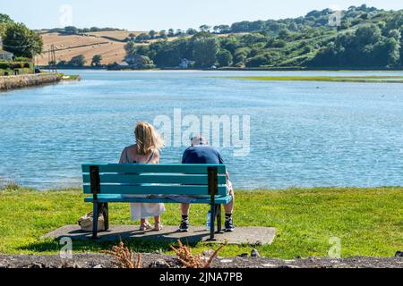 Rosscarbery, West Cork, Irlanda. 10th ago 2022. Una coppia si siede su una panchina a Rosscarbery questo pomeriggio come le temperature hanno raggiunto 24C con il sole bruciante. Met Éireann ha previsto un'onda di calore con temperaturesdue per colpire 29C questo fine settimana. Credit: AG News/Alamy Live News Foto Stock