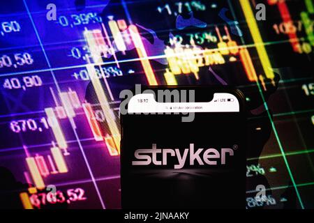 KONSKIE, POLONIA - 09 agosto 2022: Smartphone che mostra il logo di Stryker Corporation sullo sfondo del diagramma di borsa Foto Stock