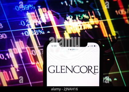 KONSKIE, POLONIA - 09 agosto 2022: Smartphone che mostra il logo della società Glencore sullo sfondo del diagramma di borsa Foto Stock