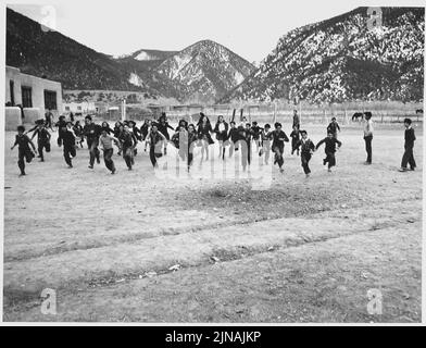 Contea di Taos, New Mexico. I bambini giocano nel cortile della scuola questa. Foto Stock