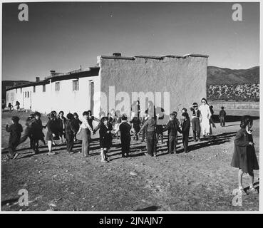 Contea di Taos, New Mexico. I bambini giocano nel cortile della scuola di Penasco. La scuola è stata costruita dai cattolici . . . Foto Stock