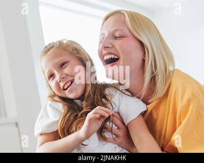 bambino sorella divertimento famiglia ragazza insieme infanzia femmina felice figlia giovane lifestyle casa indoor felicità capretto togetherness madre donna Foto Stock