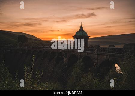 Un bellissimo tramonto con poche nuvole dietro la diga di Craig Goch nella valle di Elan, Galles. Foto Stock